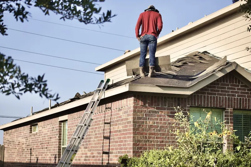 Professional roofer working on a residential roof in Wall